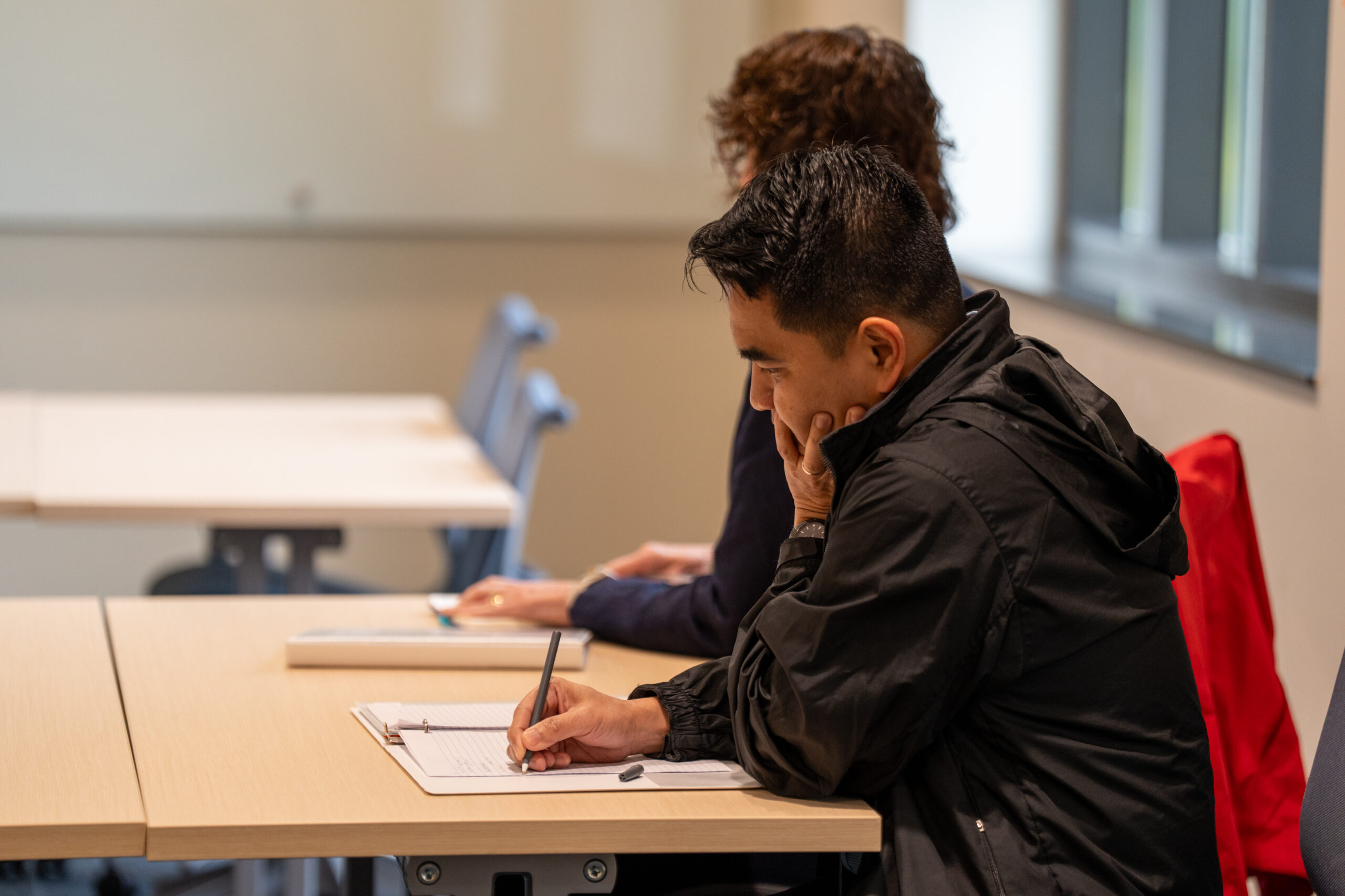A man taking notes during the 2025 NetVUE regional gathering at Hope College.