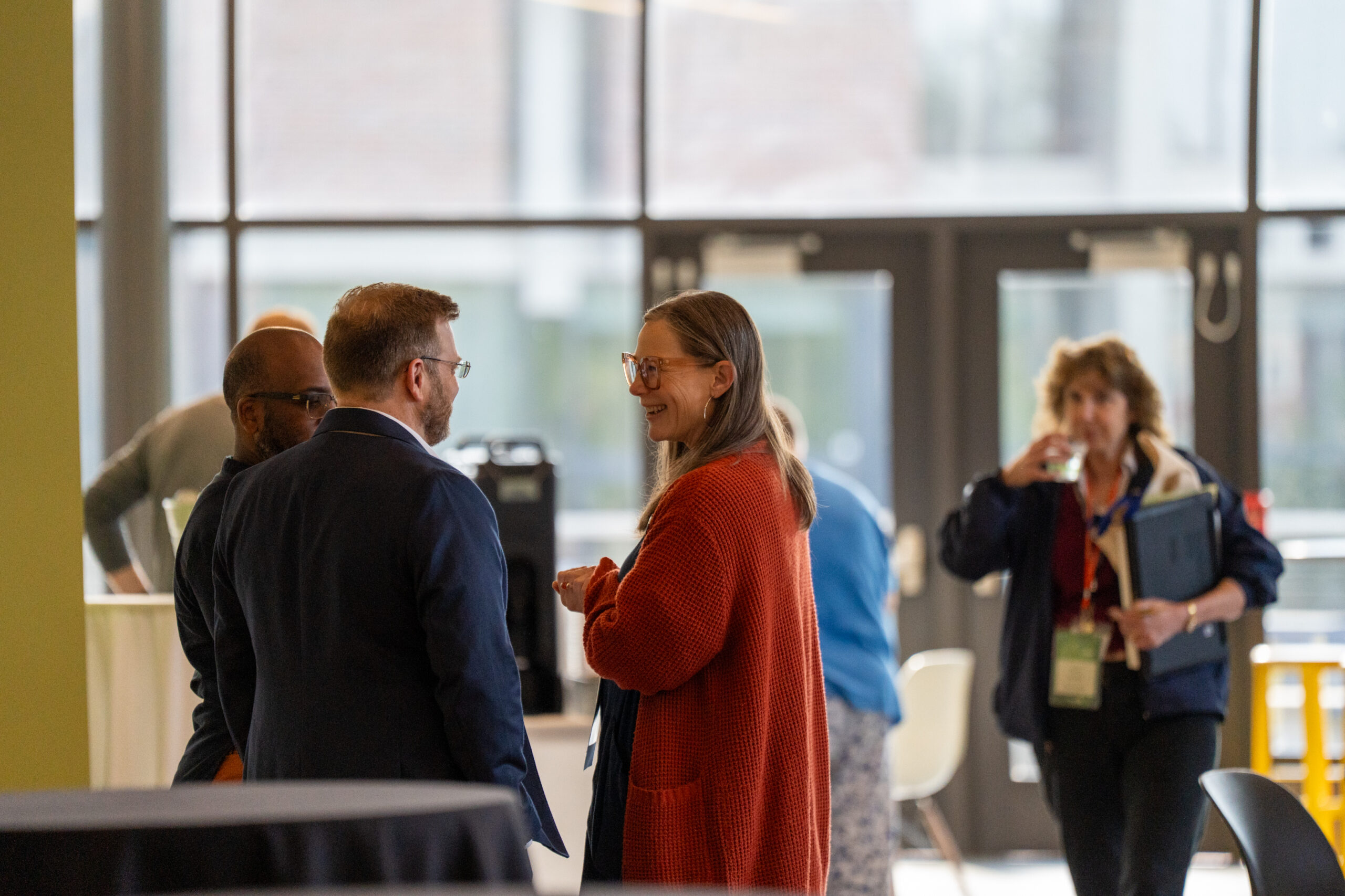 Several people standing and talking with each other before the start of the 2025 NetVUE Hope College regional gathering