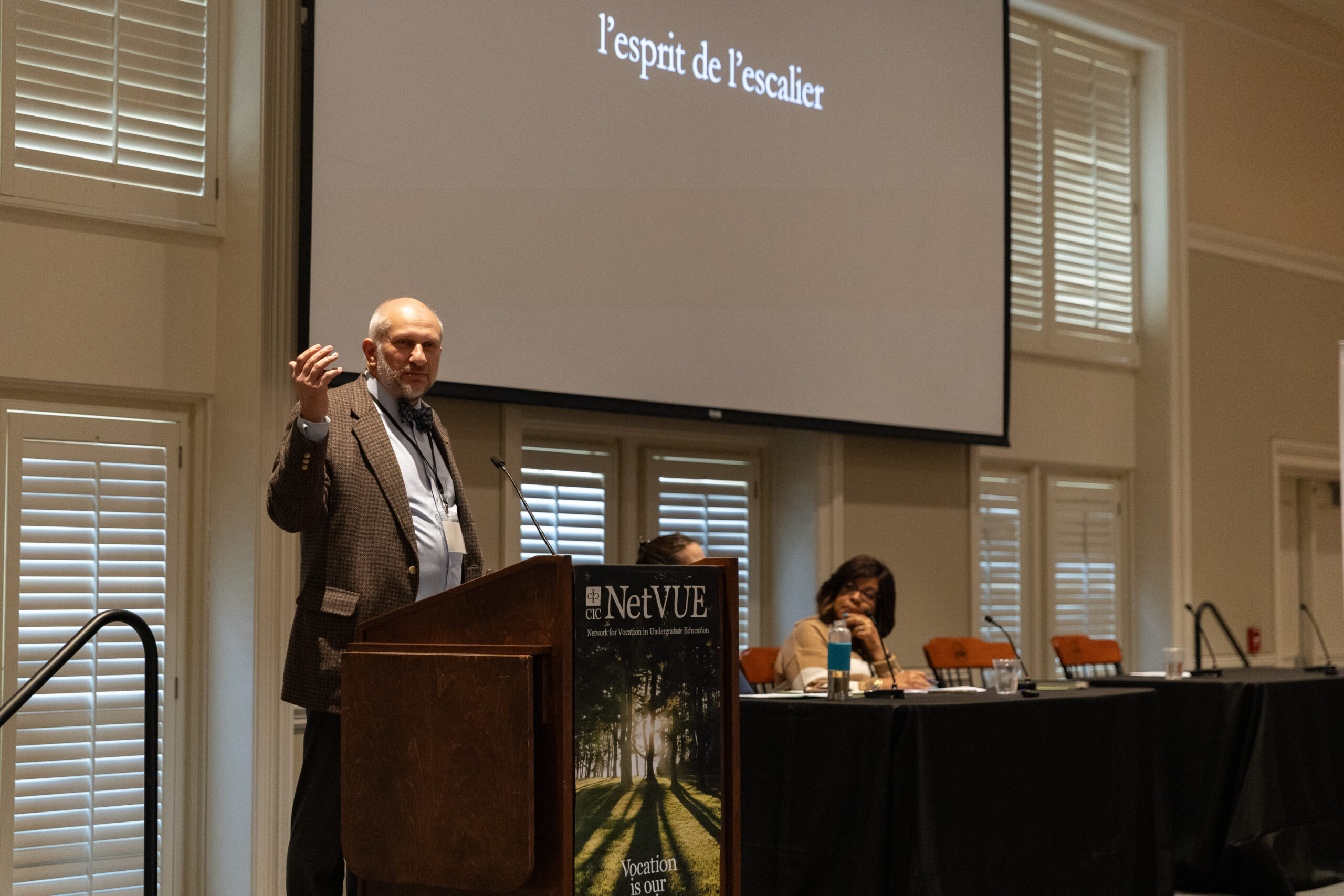 A speaker presents to participants of the 2025 NetVUE regional gathering at Furman University, with the words 
