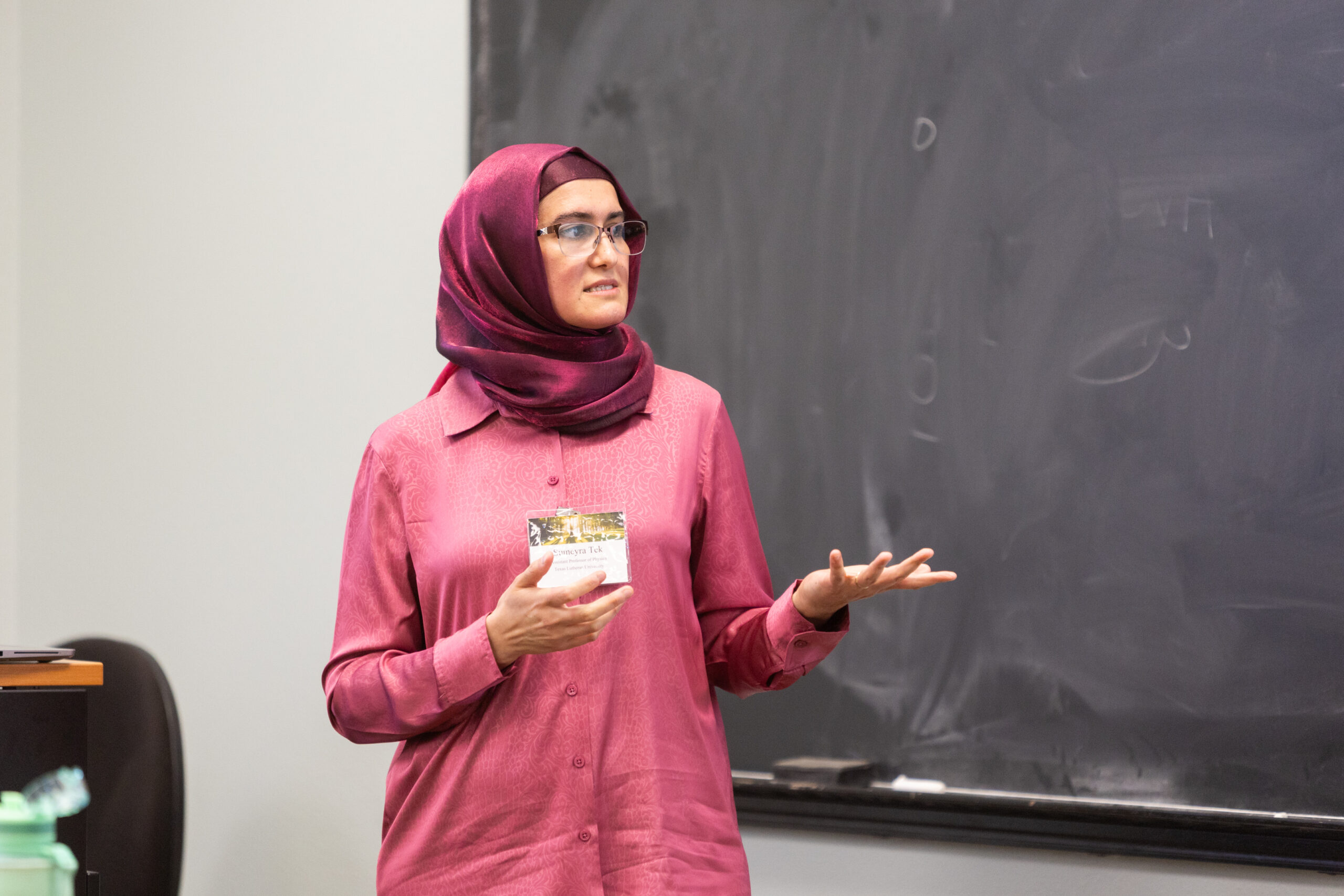 A speaker stands before a chalkboard in mid-speech at the 2024 NetVUE regional gathering hosted by Texas Lutheran University.